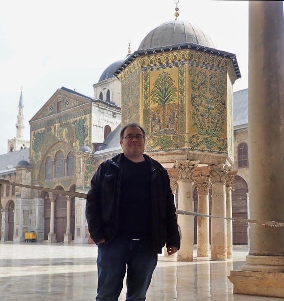 Untamed Borders guest in front of the Dome of the Treasury within the courtyard of the Umayyad Mosque in Damascus, Syria